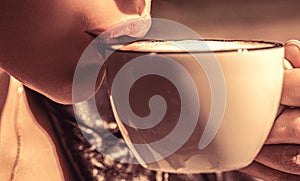 Girl drinking coffee. Woman holding cup hot coffees in hands. White mug hot coffee in the hands young girl. Female