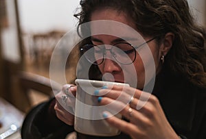 Girl drinking a cup of teacup of rose petals and red berries