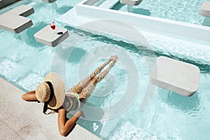 Girl drinking fruit cocktail in pool