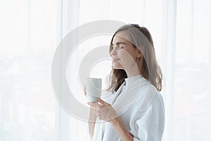 girl drinking hot coffee or tea in morning