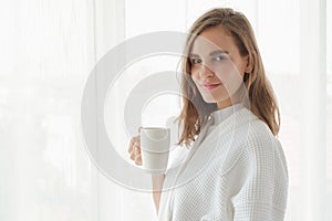 girl drinking hot coffee or tea in morning