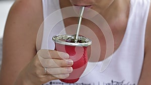 Girl drinking hot yerba mate tea. Slow motion.