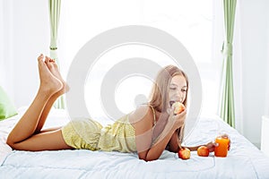 Girl drinking juice and relaxing in bedroom