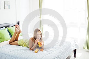 Girl drinking juice and relaxing in bedroom