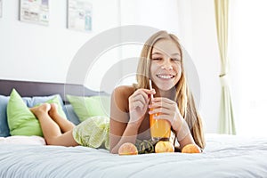 Girl drinking juice and relaxing in bedroom