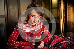 Girl drinking mulled wine on christmas and new years decorations in cafe