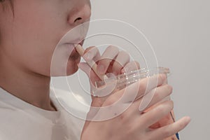 A girl drinking orange juice from the bamboo tube