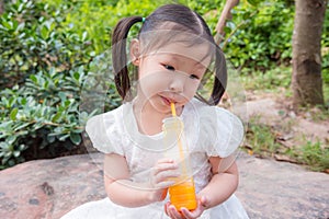 Girl drinking orange juice from bottle