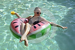 Girl drinking orange juice on watermellon float photo