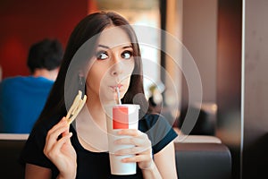 Girl Drinking Soda and Eating Fries in Fast Food Restaurant