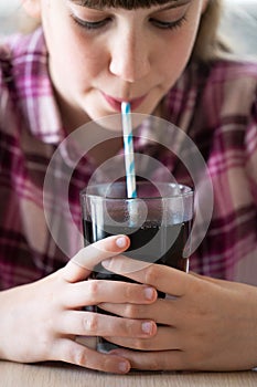 Girl Drinking Sugary Fizzy Soda From Glass With Straw