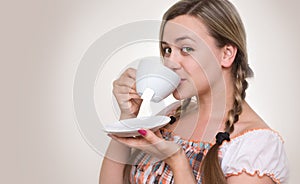 Girl drinking tea from cup.