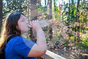 Girl drinking water from a bottle in park