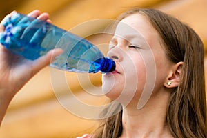 Girl drinking water outdoors - very shallow depth of field