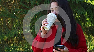 Girl drinks coffee and rewritten through a smartphone