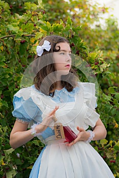 Girl drinks the drink of cherry color glass