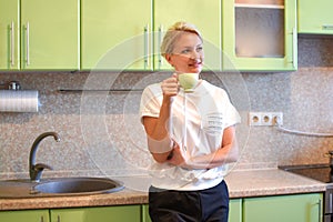 Girl drinks tea in the morning in a cozy kitchen at home. good day