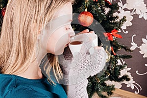 Girl drinks tea from a white cup. Close-up