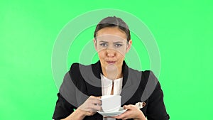 Girl drinks unpalatable coffee and is disgusted. Green screen