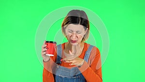 Girl drinks unpalatable coffee and is disgusted on green screen