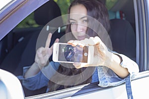 Girl driver take a selfie while driving his car. blur effect in photo