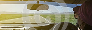 Girl driving on the autobahn, moving towards the sun in a mountainous area, the problem of poor visibility of the road