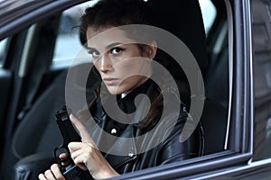 Girl driving a car with a gun in her hands