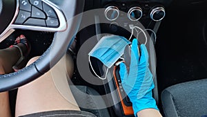 Girl driving a car with one hand in rubber glove on a gear stick