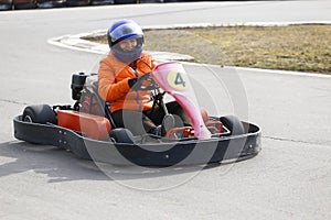 Girl is driving Go-kart car with speed in a playground racing track