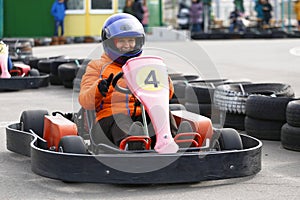 Girl is driving Go-kart car with speed in a playground racing track