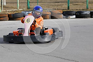 Girl is driving Go-kart car with speed in a playground racing track