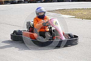 Girl is driving Go-kart car with speed in a playground racing track