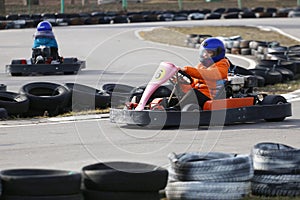 Girl is driving Go-kart car with speed in a playground racing track