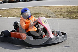 Girl is driving Go-kart car with speed in a playground racing track