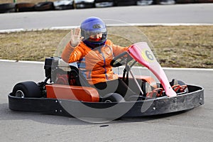 Girl is driving Go-kart car with speed in a playground racing track