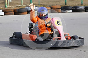 Girl is driving Go-kart car with speed in a playground racing track