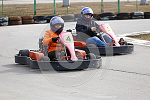 Girl is driving Go-kart car with speed in a playground racing track