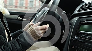 Girl driving her car in motion close up, hands on the steering wheel