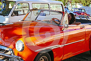 Girl driving old car in Havana, Cuba