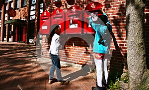 Girl dropping a letter in a red postbox