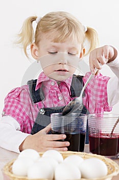 Girl during Easter eggs' coloration photo