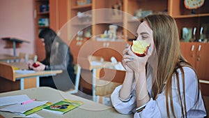 Girl eat apples in class during recess.