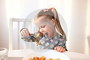 Girl eating with appetite. Tasty breakfast for children.