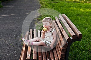 Girl eating an apple on the bench