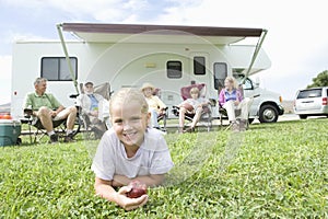 Girl Eating Apple With Family Sitting Outside RV Home photo