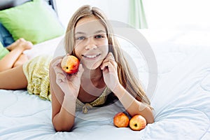 Girl eating apple and relaxing in bedroom