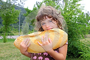 Girl eating big bread humor size hungry child photo