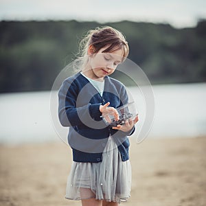 The girl eating blueberries from a glass bowl