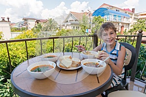 girl eating borsch at a table on the photo