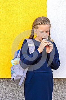 Girl eating a chocolate bar closeup. pupil with a stick of confectionery